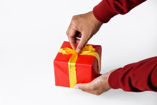 A Mans Hands Opening a Wrapped Gift photo