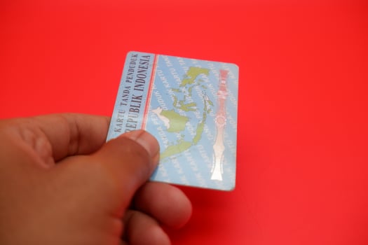 A detailed view of the Indonesian identity card resting on a red surface. The backside of the card is displayed clearly. photo
