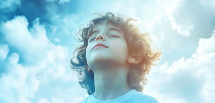 A young boy is looking up at the sky photo