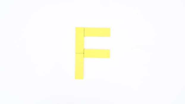 Letter F from yellow color wood block isolated on white background photo