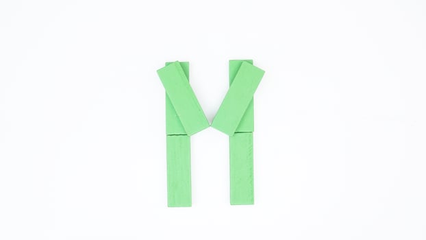 Letter M from green color wood block isolated on white background photo