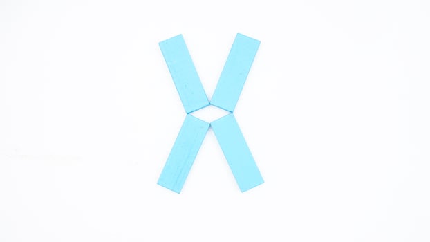 Letter X from blue color wood block isolated on white background photo