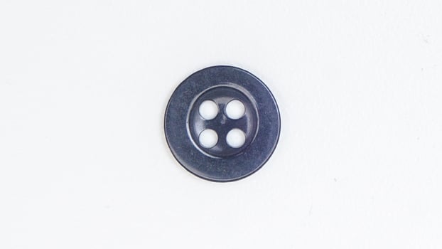 Single black sewing plastic button isolated on white background photo