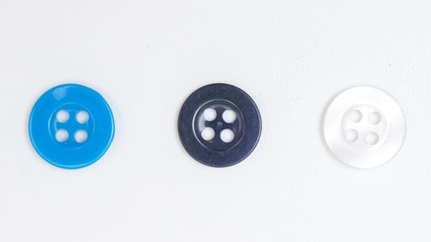 Clear, black, and blue sewing plastic buttons isolated on white background photo