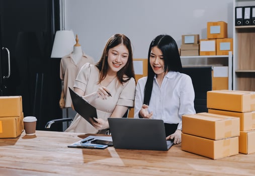 Two women in an office looking at a laptop photo