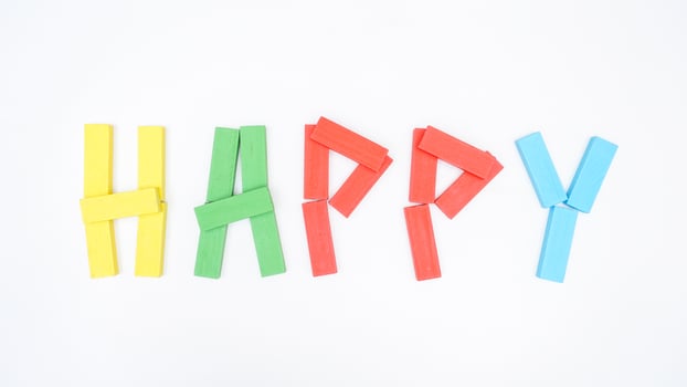 HAPPY word formed using wooden blocks of board game isolated on white background photo