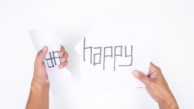 Close up of hands tearing letters UN from word UNHAPPY to get HAPPY isolated on white background photo