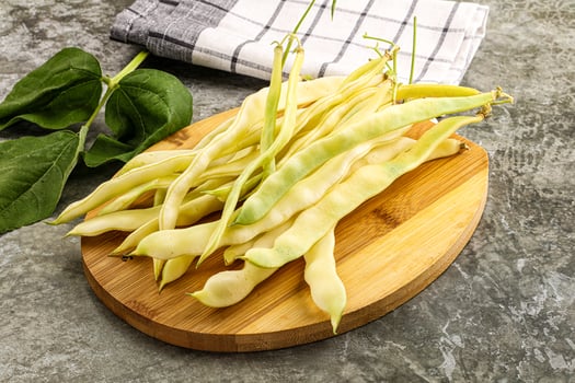 A bunch of beans on a wooden cutting board photo