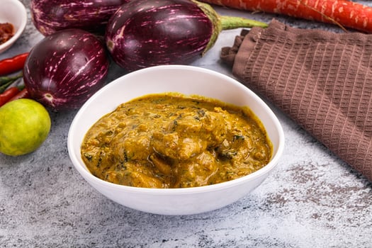 A bowl of curry with vegetables and spices photo