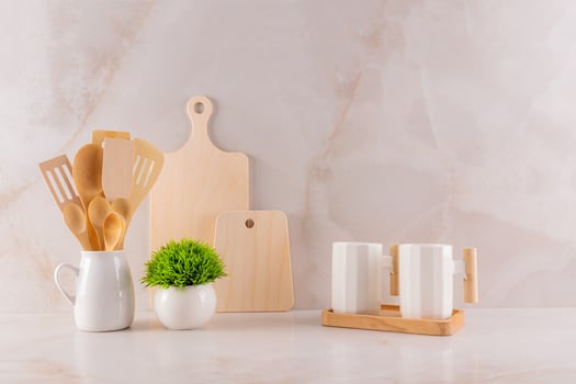 Eco-friendly kitchen, no waste concept of the house. Ceramic stylish mugs, indoor plants, a wooden cutting board on a marble countertop. Front view photo