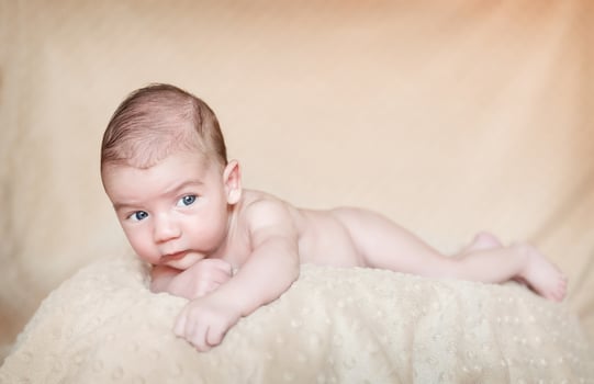 Portrait of newborn baby lying down over a blanket photo
