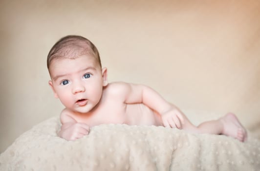 Portrait of newborn baby lying down over a blanket photo