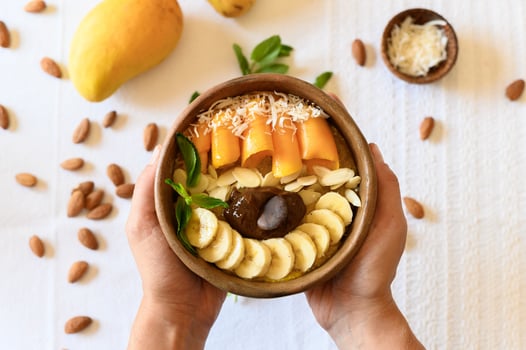 Crop person holding bowl with fruits and seeds photo