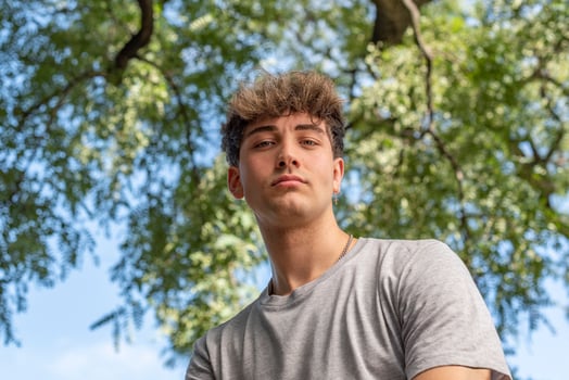 Low angle of a young man, serious, looking at the camera in a pu photo