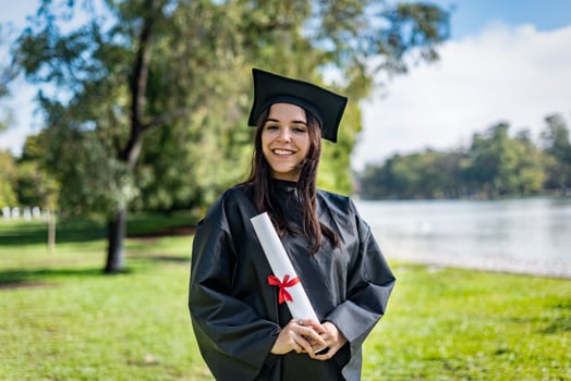 Happy caucasian graduated girl with long brown hair. She is wear photo