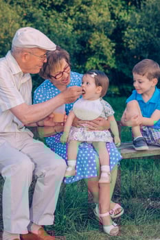 An old man feeding a baby photo