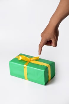 A Mans hand presenting a green gift box against a white background photo