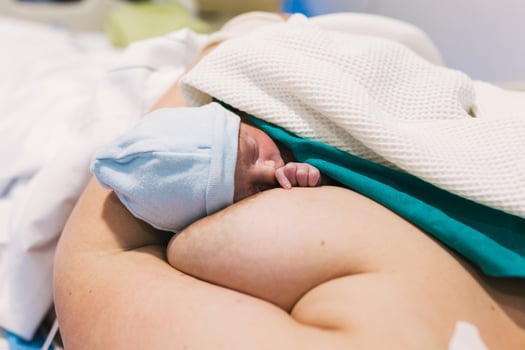 Woman holding her newborn baby after giving birth in hospital room. photo