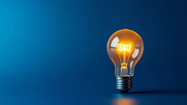 Glowing light bulb on blue background. photo