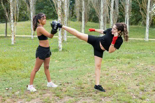 Female boxers training boxing sparring and kicking outdoors photo