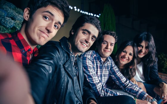 Happy friends smiling and taking selfie in party photo