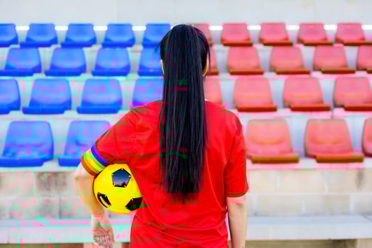 A woman in red holding a soccer ball photo