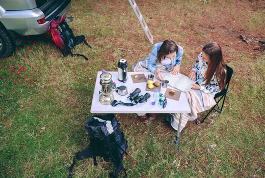 Young women looking road map in campsite photo