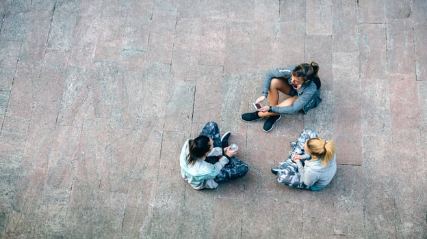 Women friends runners relaxing sitting on the floor after training photo