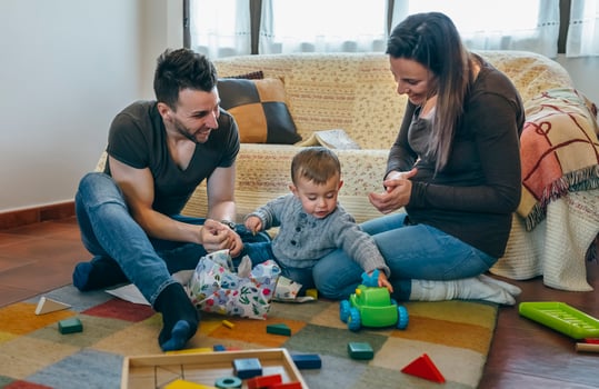 Parents with their little son opening a gift photo