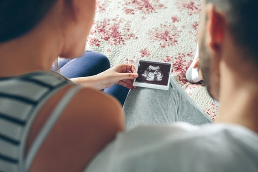 Couple looking at ultrasound of their baby photo