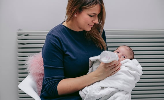 Mother giving bottle to her newborn photo