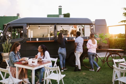 People gathering near food truck at sunset photo