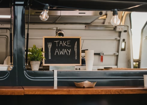 Food truck burger van outdoor in city park - Main focus on chalkboard take away sign photo