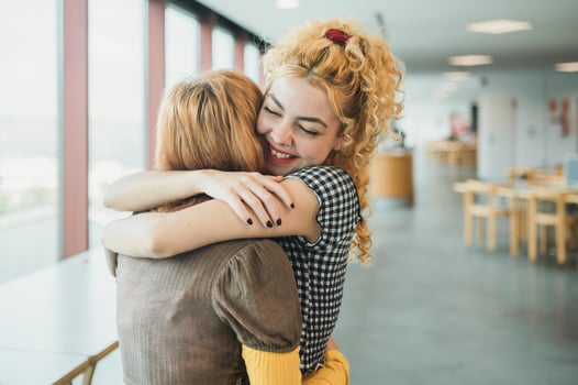 Happy teen students hugging in library photo