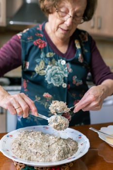 Patient aged woman coating croquettes dough with flour and egg photo