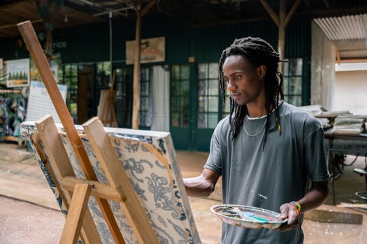 African american fine arts student paints in an outdoor classroom photo