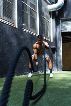 Strong Hispanic woman exercising with battle ropes photo