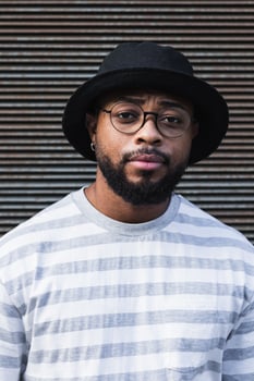 Back hipster man in hat looking at camera photo