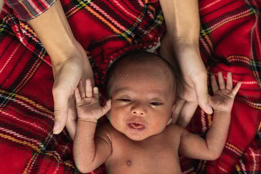 Mother with newborn baby on soft tartan blanket photo