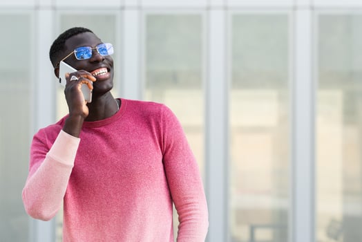 Cheerful black businessman in eyewear talking on smartphone photo