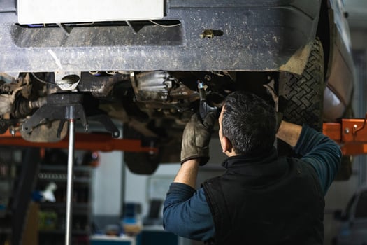 Anonymous repairman removing car details with torch during work in auto service photo