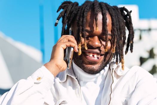 Cheerful black man talking on smartphone photo
