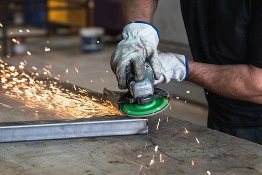 Male worker using electric grinder in workshop photo