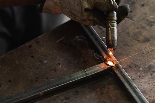 A person welding metal on a table. photo