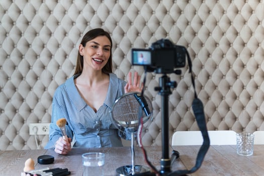 A woman is sitting at a table with a camera and a microphone photo