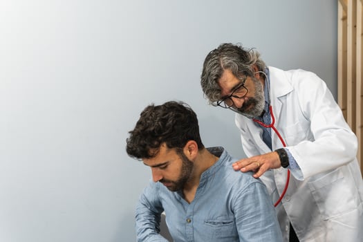 A doctor examining a man's chest photo