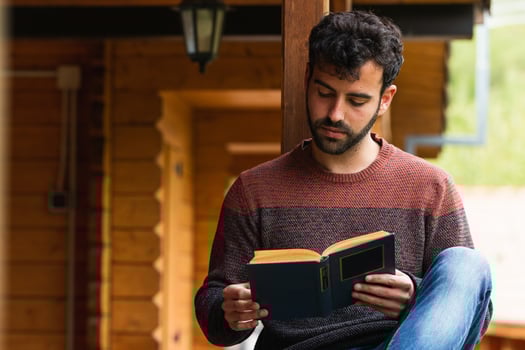 Pensive man chilling on terrace with book photo