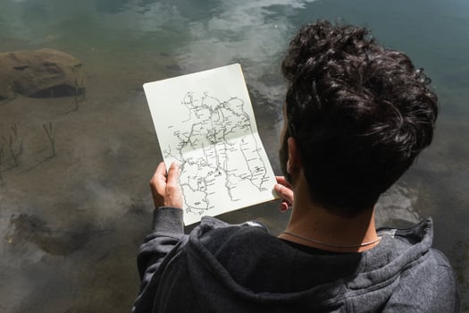 Traveling man reading map near lake in highlands photo