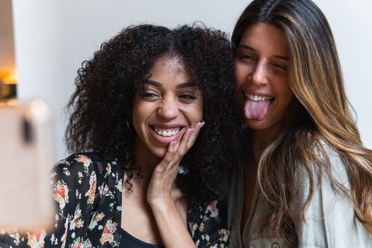 Crop smiling multiracial girlfriends taking selfie on smartphone photo