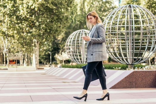 A woman in a suit and heels walking down a street photo